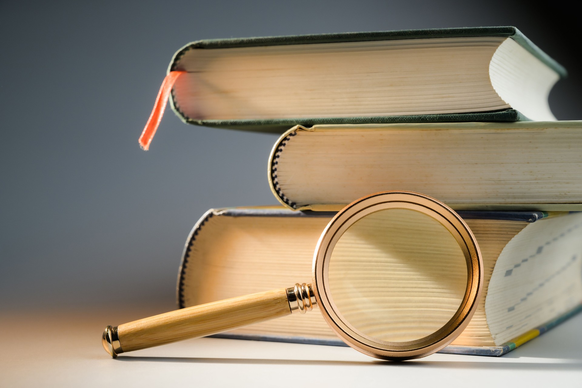 Magnifying glass and thick books